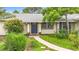 Attractive front entryway with vibrant blue door and decorative trim surrounded by lush, green landscaping and a curved sidewalk at 408 67Th W Ave, Bradenton, FL 34207