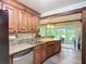Beautiful kitchen with wooden cabinets, stainless steel dishwasher, and an open view into a bright Florida room at 408 67Th W Ave, Bradenton, FL 34207