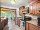 Well-appointed kitchen featuring wooden cabinetry, stainless steel appliances, and an opening to the Florida room at 408 67Th W Ave, Bradenton, FL 34207