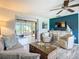 Inviting living room showcases a sliding glass door to the lanai, comfortable seating, and attractive decor and furnishings at 408 67Th W Ave, Bradenton, FL 34207