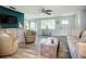 Cozy living room with an open layout includes stylish furnishings, wood-look floors, and a view of the entry and dining areas at 408 67Th W Ave, Bradenton, FL 34207