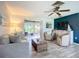 Comfortable living room features a sliding glass door to the lanai, stylish furnishings, and a decorative ceiling fan at 408 67Th W Ave, Bradenton, FL 34207