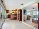 Tiled living room leading to a bar and furnished sunroom with seating at 408 67Th W Ave, Bradenton, FL 34207