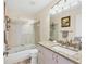 Bathroom featuring granite countertop, white vanity, a bathtub with shower, and a big mirror at 4107 Brittany Ln # 18, Sarasota, FL 34233