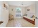 Cozy bedroom featuring tile floors, futon couch, and natural light from the large window at 4107 Brittany Ln # 18, Sarasota, FL 34233