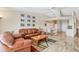 Bright living room with tile floors, white walls, leather couches, and dining area at 4107 Brittany Ln # 18, Sarasota, FL 34233