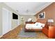 A bedroom with wood parquet floors, a modern dresser, and an attached bathroom at 4107 Brittany Ln # 18, Sarasota, FL 34233