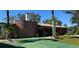 Charming single-story home with a brick accent wall, mature landscaping, and a green driveway at 4158 Prudence Dr, Sarasota, FL 34235
