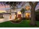 Elegant two-story home with a red front door, stone accents, manicured lawn, and three-car garage at 4410 67Th Avenue E Cir, Sarasota, FL 34243
