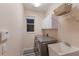 Functional laundry room with modern washer and dryer, ample storage cabinets and a utility sink at 4410 67Th Avenue E Cir, Sarasota, FL 34243