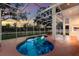 Inviting kidney-shaped pool enclosed by a screen, offering relaxation and entertainment with sunset views at 4410 67Th Avenue E Cir, Sarasota, FL 34243