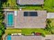 Bird's eye view of a private backyard pool and patio with solar panels atop a well-maintained roof at 5004 Creekside Trl, Sarasota, FL 34243