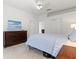 Clean bedroom design with a wooden dresser and light blue bedspread at 5004 Creekside Trl, Sarasota, FL 34243