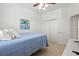 Bright bedroom with a blue bedspread, ceiling fan, closet and an colorful piece of art at 5004 Creekside Trl, Sarasota, FL 34243