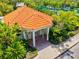 Charming clubhouse exterior with a clay tile roof, surrounded by meticulously landscaped gardens and tropical plants at 5004 Creekside Trl, Sarasota, FL 34243