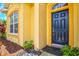 Home's front entrance with a dark blue door, textured siding, and decorative stone landscaping at 5004 Creekside Trl, Sarasota, FL 34243