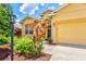 Close-up of home's entrance featuring vibrant flowers, manicured landscaping, and inviting architecture at 5004 Creekside Trl, Sarasota, FL 34243