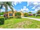 Beautiful home with lush green lawn, mature landscaping, and vibrant flowers under a sunny sky at 5004 Creekside Trl, Sarasota, FL 34243
