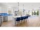 Modern kitchen featuring white cabinets, blue backsplash, quartz counters, stainless steel appliances, and a central island with seating at 5004 Creekside Trl, Sarasota, FL 34243