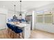 Contemporary kitchen with white cabinets, blue backsplash, stainless steel appliances, a quartz island, and stylish pendant lighting at 5004 Creekside Trl, Sarasota, FL 34243