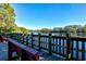 Scenic lake view featuring benches on a wooden pier overlooking the tranquil waters surrounded by lush greenery at 5004 Creekside Trl, Sarasota, FL 34243