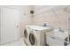 Functional laundry room with modern washer and dryer, utility sink and a door at 5004 Creekside Trl, Sarasota, FL 34243