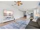 Bright living room featuring a ceiling fan, TV, and a modern glass coffee table at 5004 Creekside Trl, Sarasota, FL 34243