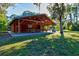Wooden pavilion with picnic tables, nestled in a grassy area shaded by mature trees at 5004 Creekside Trl, Sarasota, FL 34243