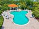 Community pool featuring an uniquely shaped pool, cabana, chairs, playground and a seating area at 5004 Creekside Trl, Sarasota, FL 34243