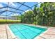 Inviting in-ground pool, fully screened for outdoor enjoyment, surrounded by lush tropical landscaping at 5004 Creekside Trl, Sarasota, FL 34243