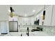 Open-concept kitchen featuring stainless steel appliances, white cabinetry, and stylish pendant lighting at 5009 Jody Ave, North Port, FL 34288