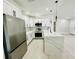 Open-concept kitchen with stainless steel appliances, white cabinetry, granite counters, and a view to the living space at 5009 Jody Ave, North Port, FL 34288