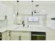 Bright kitchen with white cabinets, granite countertops, stainless steel appliances, and stylish pendant lights at 5009 Jody Ave, North Port, FL 34288