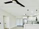 A stylish fan and open-concept kitchen with stainless steel appliances, white cabinetry, and pendant lighting at 5009 Jody Ave, North Port, FL 34288