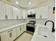 Well-equipped kitchen boasting white cabinets, stainless steel appliances, and modern countertops at 5009 Jody Ave, North Port, FL 34288