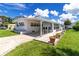 Charming home featuring a covered patio, landscaped garden beds, and a well-kept lawn with a concrete driveway at 508 50Th Avenue W Plz, Bradenton, FL 34207