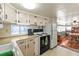 Functional kitchen with white cabinets, updated appliances, and an open layout to the dining area, creating a welcoming atmosphere at 508 50Th Avenue W Plz, Bradenton, FL 34207
