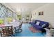 Inviting sunroom featuring a blue futon, dining set, and bright windows with decorative curtains for natural light at 508 50Th Avenue W Plz, Bradenton, FL 34207