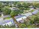 Aerial view shows a well-kept home with fenced yard, mature tree, and neighborhood at 528 Manor Dr, Dunedin, FL 34698