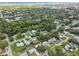 Expansive aerial view showcasing a lush, green neighborhood with homes near the water at 528 Manor Dr, Dunedin, FL 34698