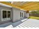 Patio area with light wooden pergola, gray exterior, and freshly painted floor at 528 Manor Dr, Dunedin, FL 34698