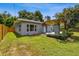 Well-maintained backyard with lush green lawn and wooden fence bordering the gray home at 528 Manor Dr, Dunedin, FL 34698