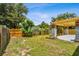 Lush backyard featuring a wooden fence, pergola patio, and ample green space at 528 Manor Dr, Dunedin, FL 34698