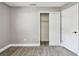 Neutral bedroom showcasing light gray walls and wood-look floors, closet with sliding door, and paneled door at 528 Manor Dr, Dunedin, FL 34698