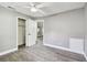 Neutral bedroom showcasing light gray walls and wood-look floors, walk-in closet, and door to an adjacent room at 528 Manor Dr, Dunedin, FL 34698