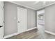 Neutral bedroom showcasing light gray walls and wood-look floors, door to hall, and door to an adjacent room at 528 Manor Dr, Dunedin, FL 34698