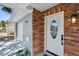 Inviting front entryway featuring a brick facade and covered porch at 528 Manor Dr, Dunedin, FL 34698