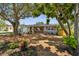 Charming single-story home with well-manicured lawn, lush landscaping, and a cozy bench under a window at 528 Manor Dr, Dunedin, FL 34698