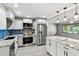 Updated kitchen with stainless steel appliances, granite countertops, blue backsplash, and center island with pendant lights at 528 Manor Dr, Dunedin, FL 34698