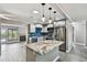 Modern kitchen with stainless steel appliances, granite counters, blue backsplash, and an island with pendant lighting at 528 Manor Dr, Dunedin, FL 34698